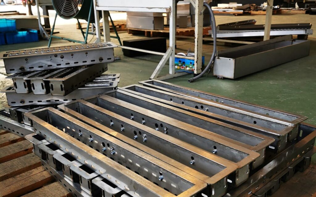 Fabricated stainless-steel burner housings prepared for assembly
