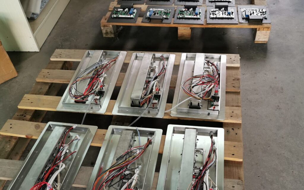 Control boards and stainless-steel burner housings prepared for assembly