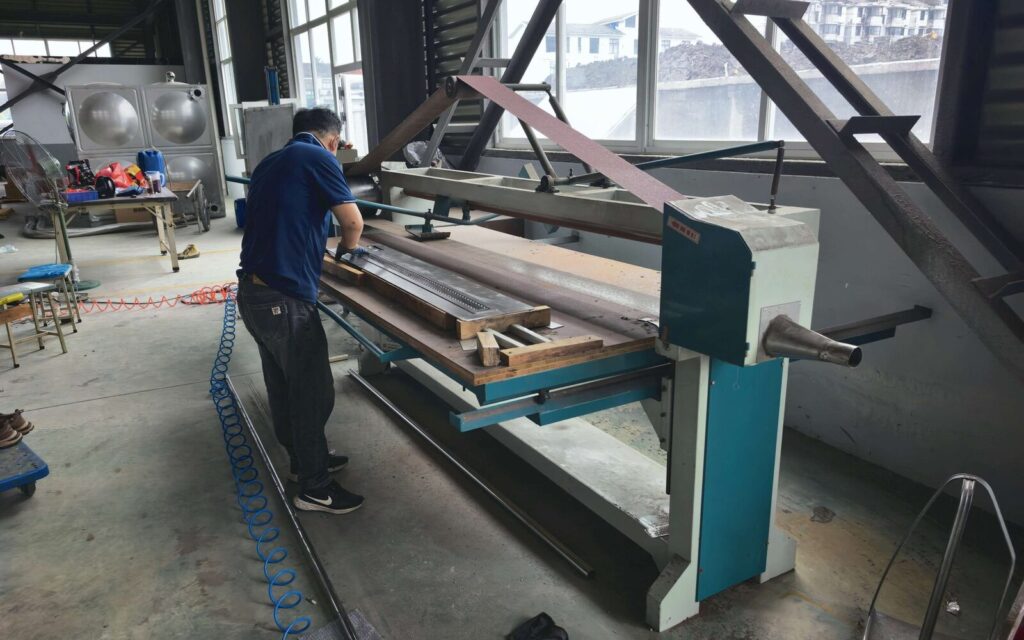 SXFireplace worker grinding and finishing a stainless-steel fireplace component