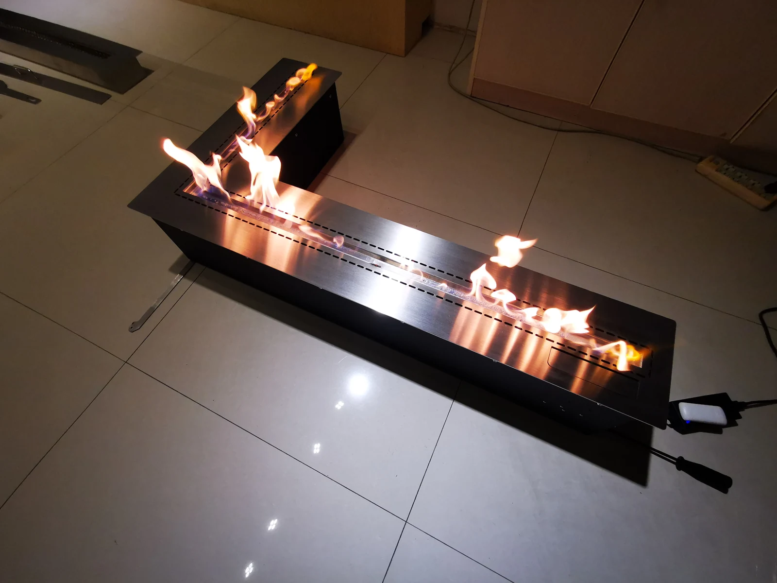 Historical factory photo of an L-shaped ethanol burner during a trial burn