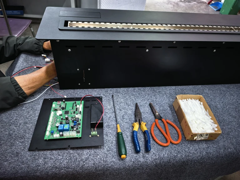 工作台上的壁炉燃烧器组件、控制板与手动工具